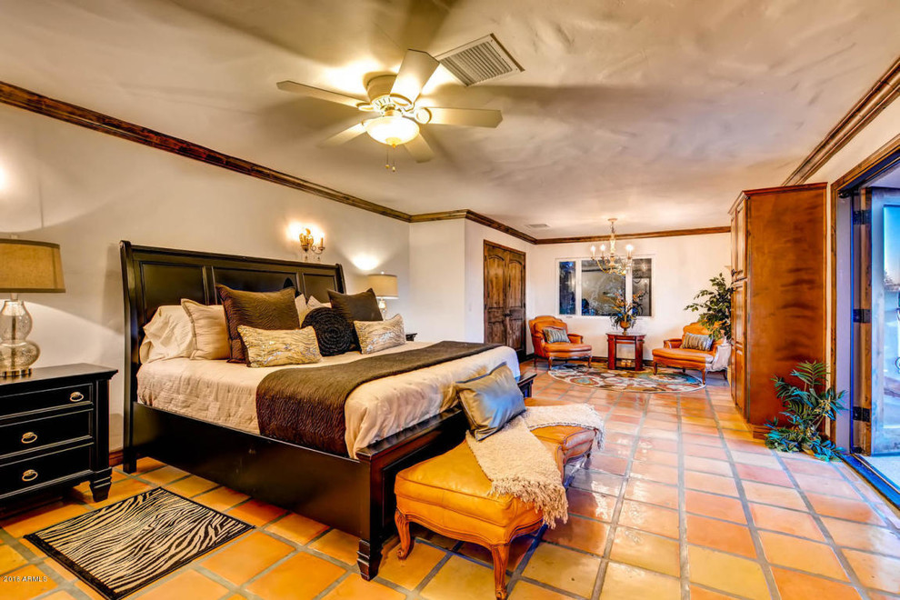Idée de décoration pour une grande chambre parentale sud-ouest américain avec un mur blanc, tomettes au sol et un sol orange.