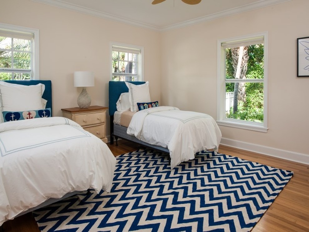 Foto de habitación de invitados costera de tamaño medio sin chimenea con paredes beige y suelo de madera clara