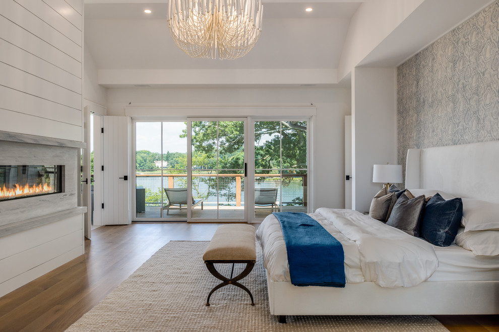 Bedroom - transitional master medium tone wood floor and brown floor bedroom idea in New York with white walls, a ribbon fireplace and a stone fireplace