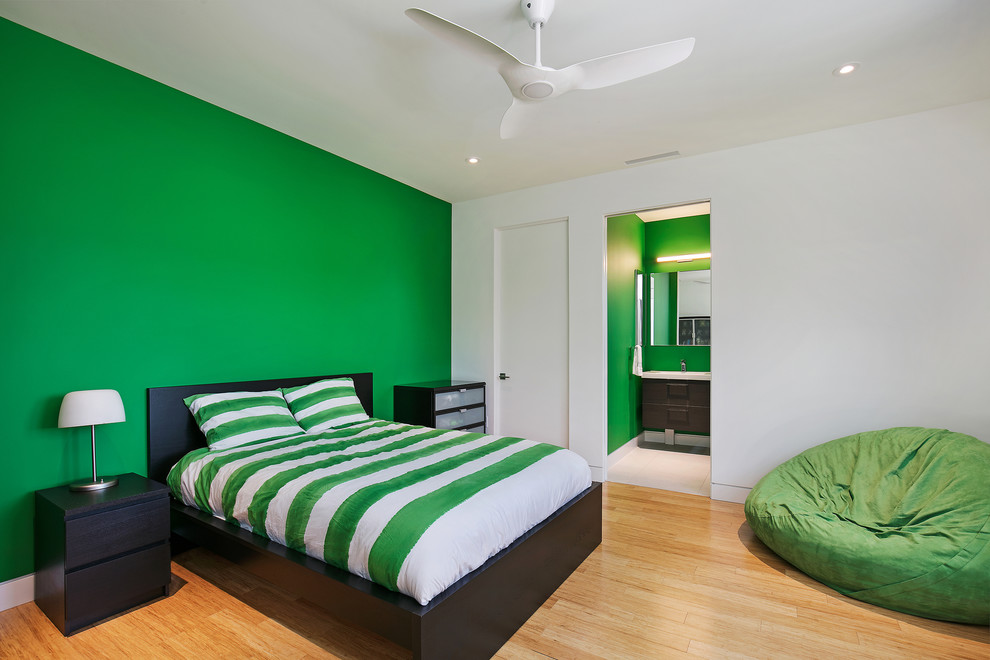 Cette photo montre une chambre d'amis moderne de taille moyenne avec un mur vert, parquet en bambou, aucune cheminée et un sol multicolore.