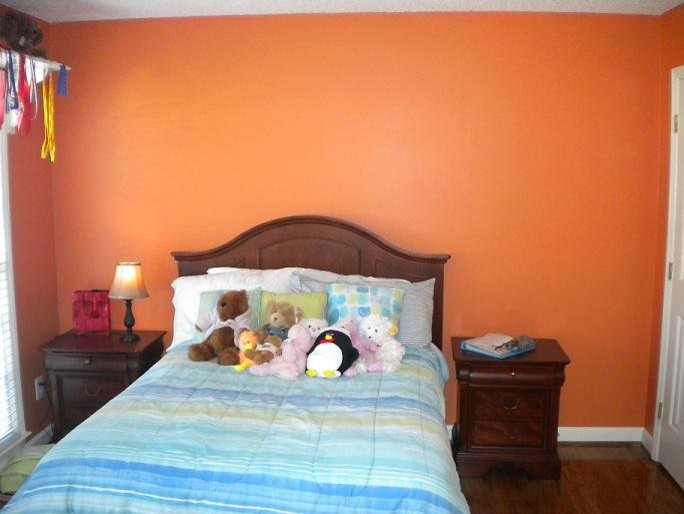 Inspiration för små klassiska gästrum, med orange väggar och mörkt trägolv