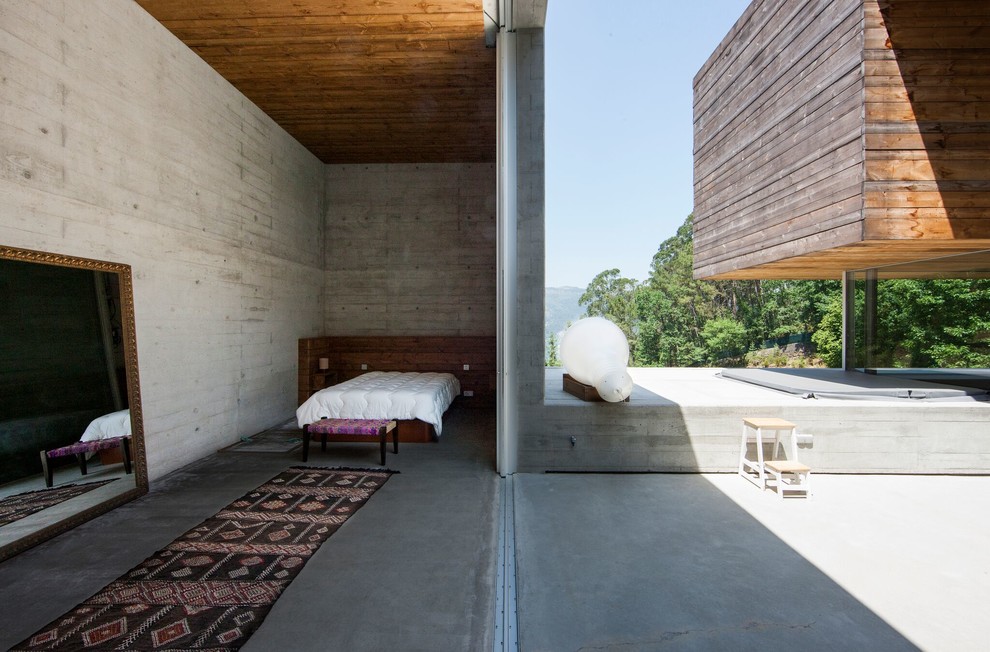 Идея дизайна: спальня в современном стиле с серыми стенами, бетонным полом и серым полом