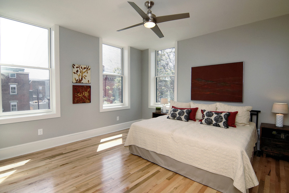 Ejemplo de dormitorio principal clásico renovado grande sin chimenea con paredes grises, suelo de madera clara y suelo beige