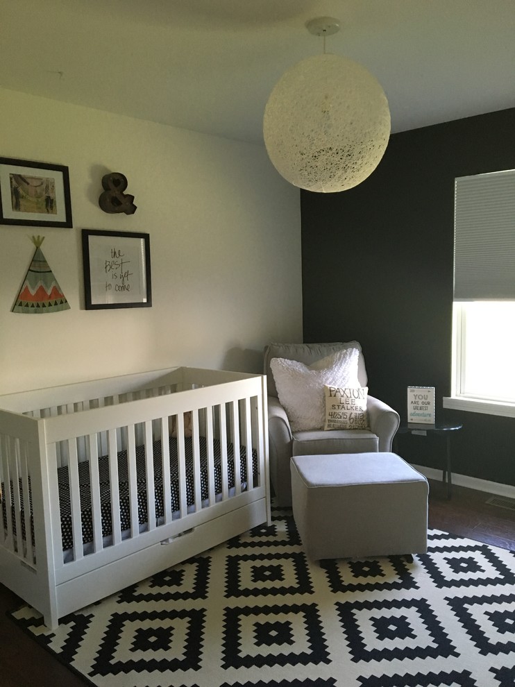 Idée de décoration pour une chambre de bébé tradition de taille moyenne avec un mur blanc et parquet foncé.