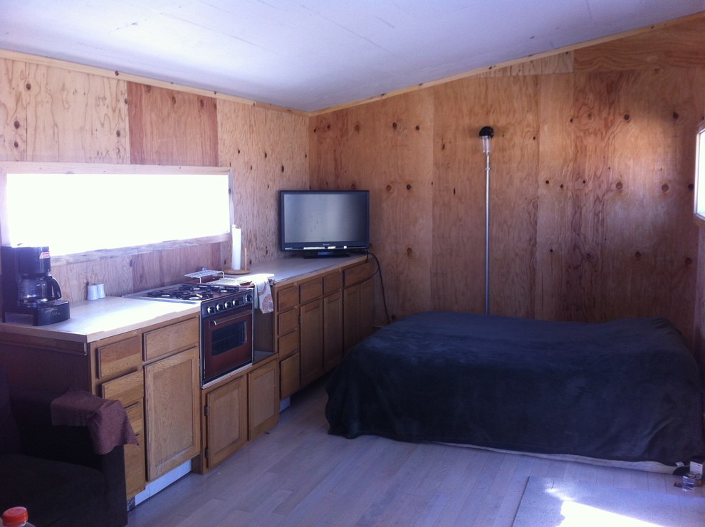 This is an example of a small rustic bedroom in Denver with light hardwood flooring.