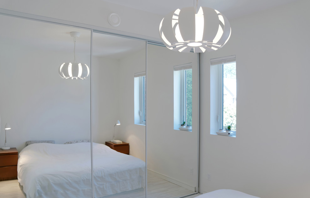 Kleines Modernes Schlafzimmer mit weißer Wandfarbe und hellem Holzboden in Toronto