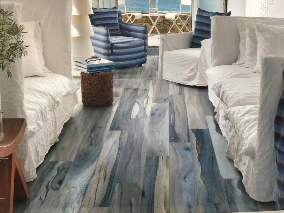Diseño de dormitorio principal marinero de tamaño medio sin chimenea con paredes blancas, suelo de madera en tonos medios y suelo azul