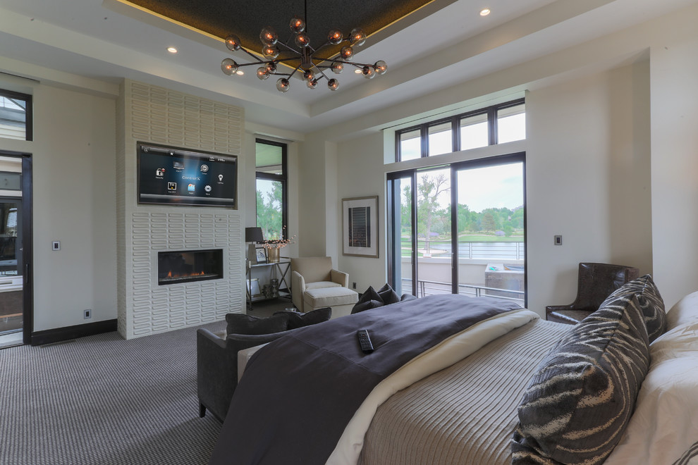 Photo of a contemporary master bedroom in Other with beige walls, carpet, a standard fireplace and multi-coloured floors.