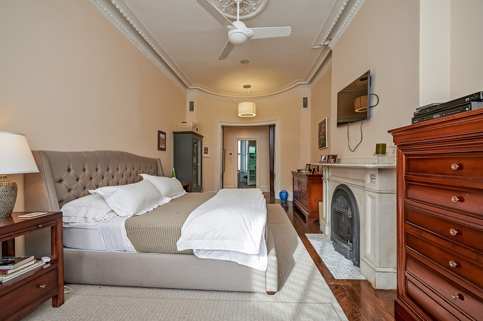 ボストンにある中くらいなトラディショナルスタイルのおしゃれな主寝室 (ベージュの壁、濃色無垢フローリング、標準型暖炉、漆喰の暖炉まわり、ベージュの床) のレイアウト