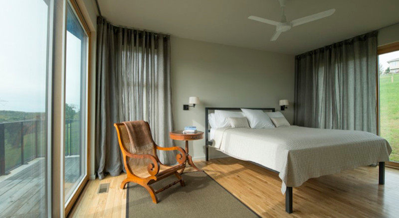Ejemplo de dormitorio principal escandinavo de tamaño medio sin chimenea con paredes beige y suelo de madera clara