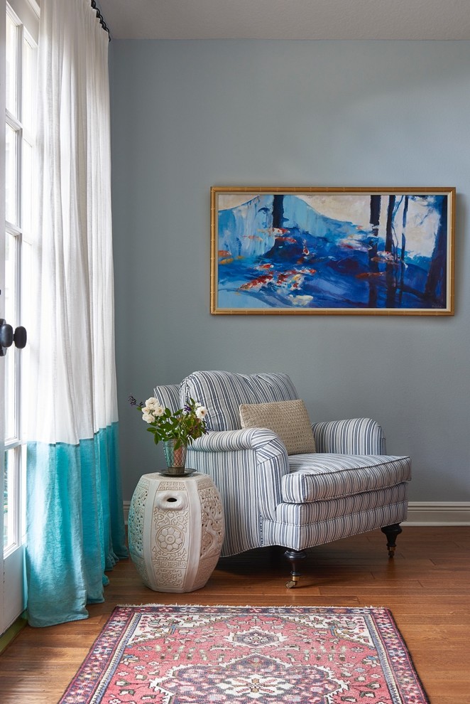 Idée de décoration pour une chambre parentale bohème de taille moyenne avec un mur bleu, un sol en bois brun et aucune cheminée.