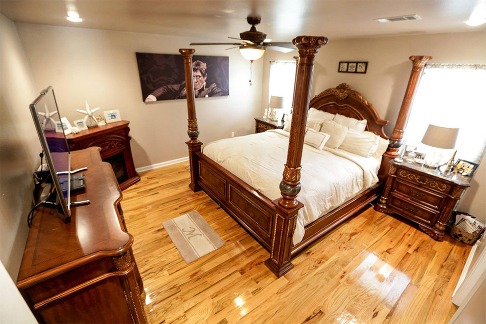 Mittelgroßes Klassisches Hauptschlafzimmer mit beiger Wandfarbe, braunem Holzboden, Eckkamin, Kaminumrandung aus Holz und braunem Boden in New Orleans
