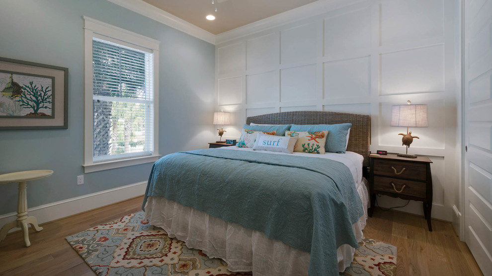Ejemplo de habitación de invitados costera de tamaño medio con paredes azules y suelo de madera clara