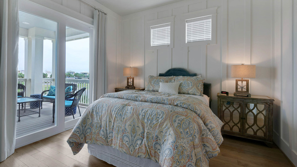 Inspiration for a small coastal guest light wood floor bedroom remodel in Miami with no fireplace and white walls