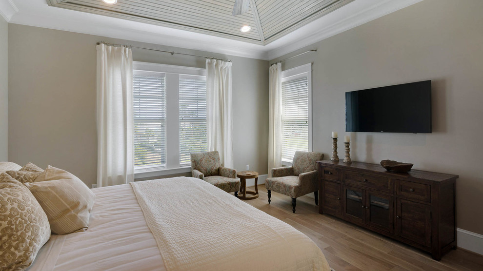 Diseño de habitación de invitados costera grande con paredes grises y suelo de madera clara