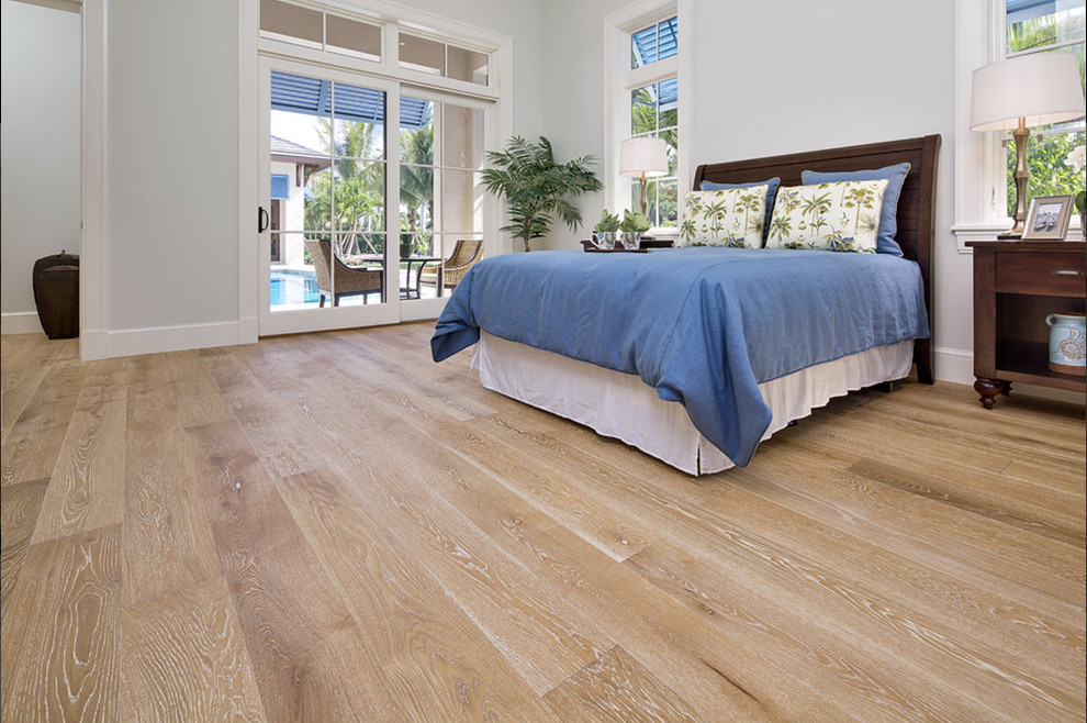 Example of a large island style master light wood floor bedroom design in New York with gray walls