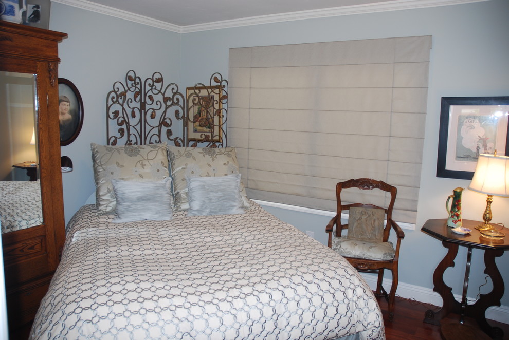 Cette image montre une petite chambre d'amis design avec un mur gris et parquet foncé.