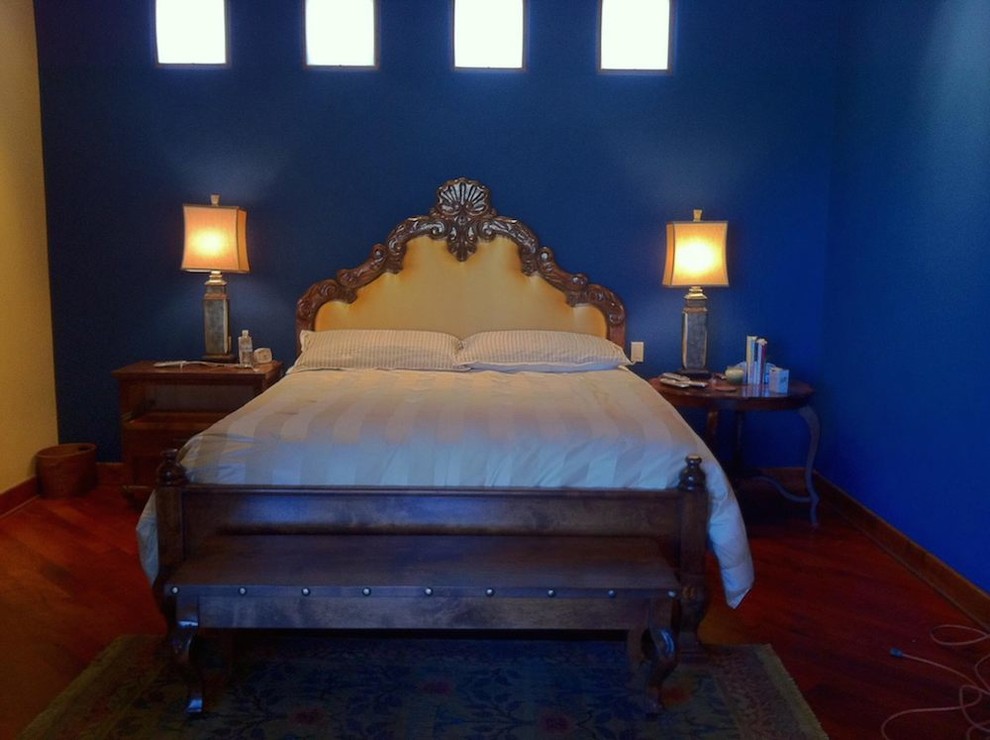 Réalisation d'une chambre parentale sud-ouest américain de taille moyenne avec un mur bleu et un sol en bois brun.