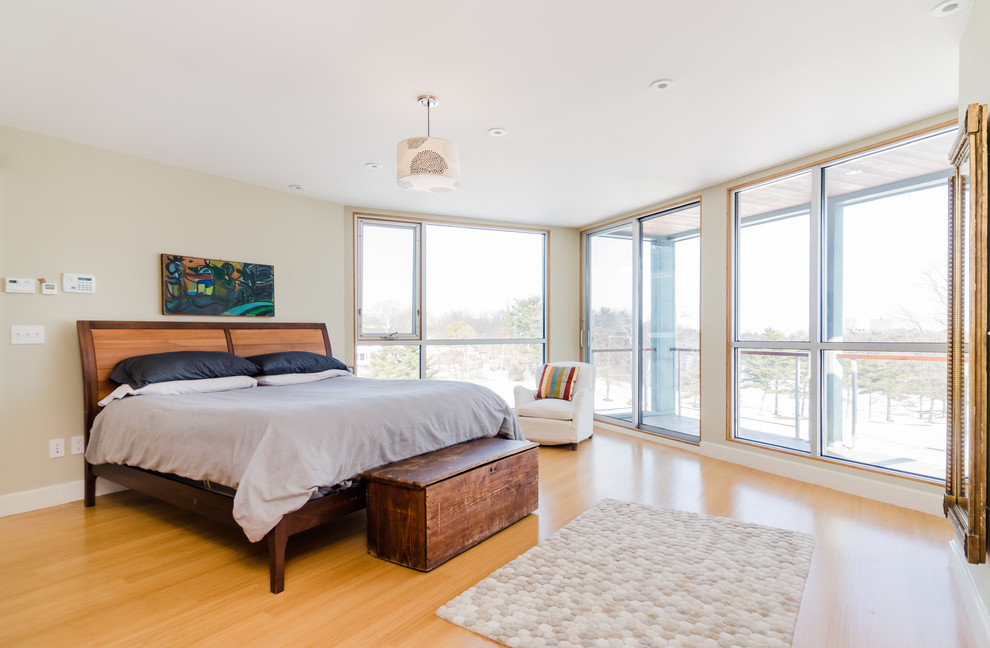 This is an example of a large scandi master bedroom in Boston with beige walls, light hardwood flooring and beige floors.