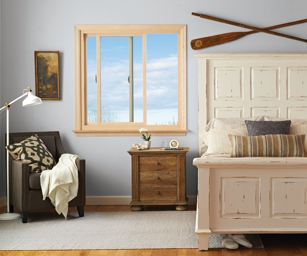 Ejemplo de habitación de invitados campestre de tamaño medio sin chimenea con paredes grises, suelo de madera en tonos medios y suelo marrón