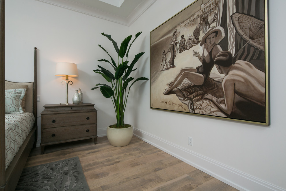 Inspiration for a large tropical master light wood floor bedroom remodel in Miami with white walls and no fireplace