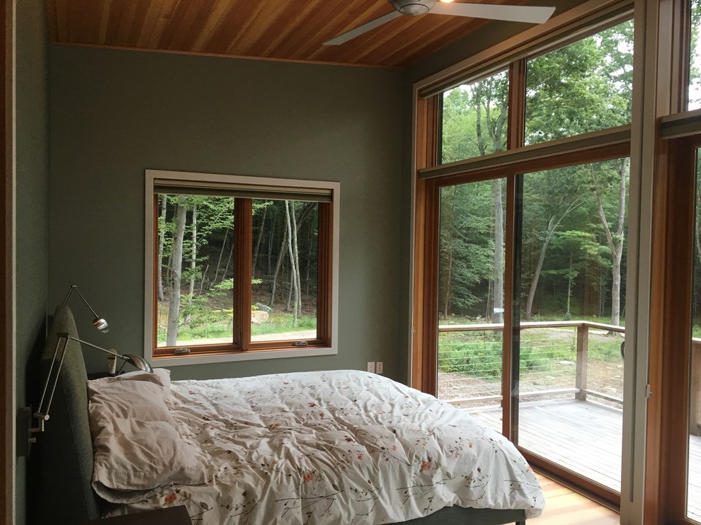 Cette photo montre une chambre parentale chic de taille moyenne avec un mur vert, un sol en bois brun et aucune cheminée.
