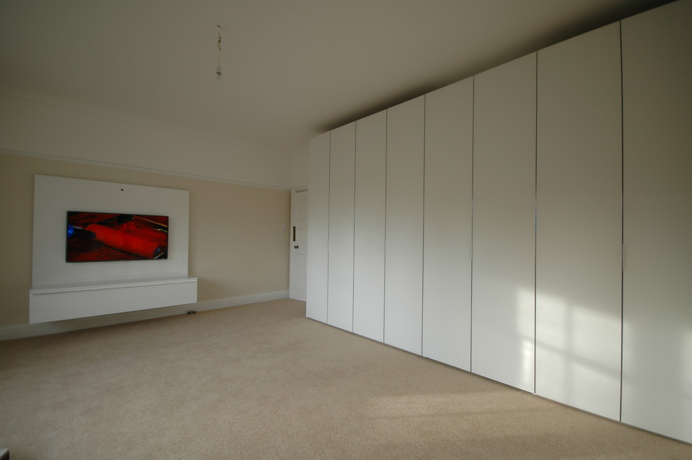 Diseño de dormitorio principal actual de tamaño medio con paredes blancas y moqueta