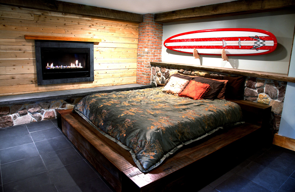 フィラデルフィアにある中くらいなコンテンポラリースタイルのおしゃれな主寝室 (グレーの壁、スレートの床、標準型暖炉、木材の暖炉まわり) のインテリア