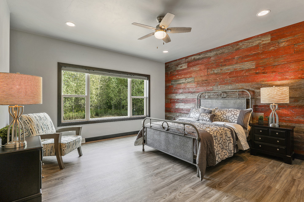 Landhausstil Schlafzimmer mit roter Wandfarbe, hellem Holzboden und grauem Boden in Sonstige