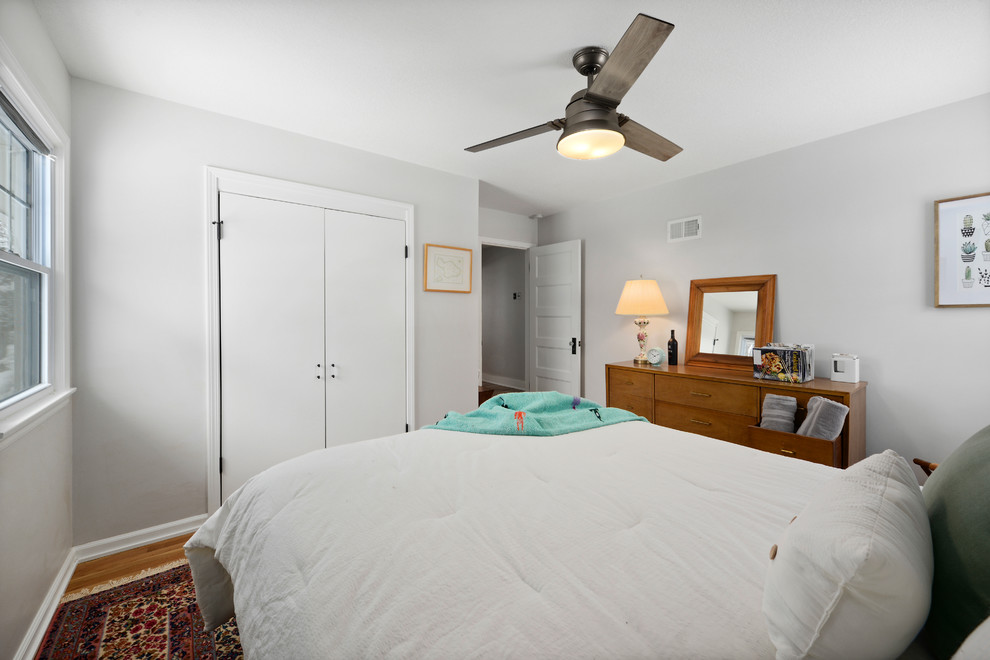 カンザスシティにある小さなトラディショナルスタイルのおしゃれな客用寝室 (白い壁、無垢フローリング) のレイアウト