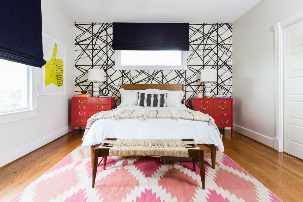 Immagine di una camera degli ospiti bohémian di medie dimensioni con pareti bianche, pavimento in legno massello medio, nessun camino e pavimento marrone