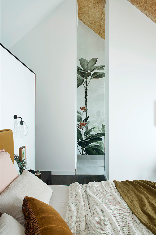 Cette image montre une chambre parentale design de taille moyenne avec un mur blanc, sol en stratifié et un sol noir.