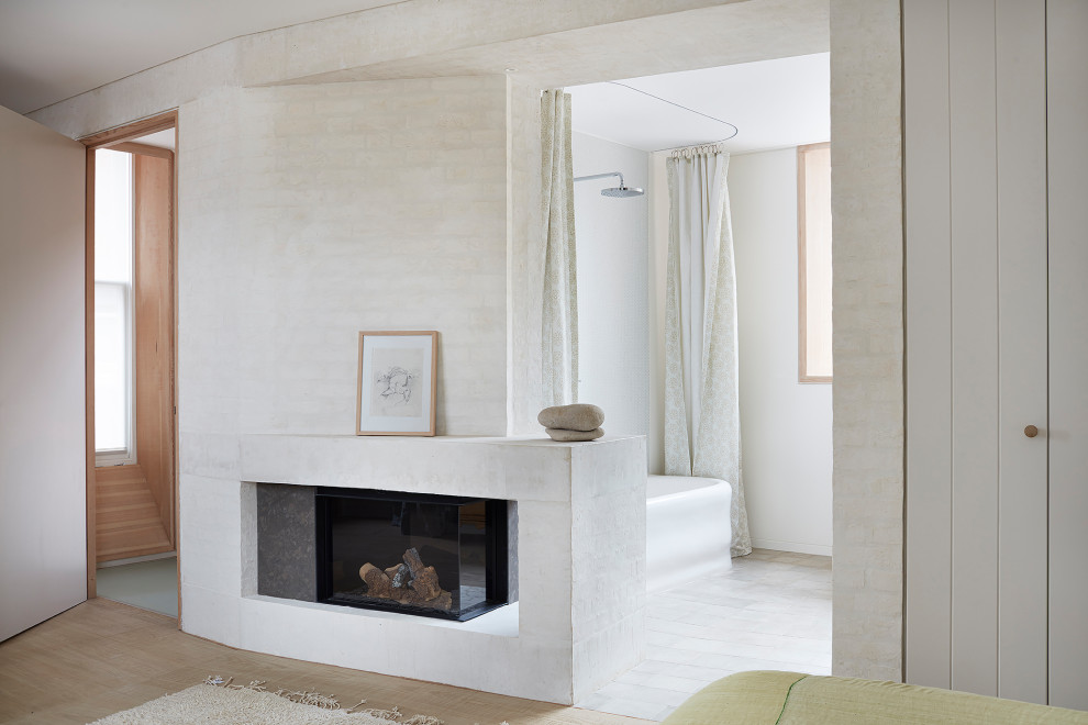 ロンドンにある中くらいなコンテンポラリースタイルのおしゃれな主寝室 (白い壁、淡色無垢フローリング、両方向型暖炉、レンガの暖炉まわり、茶色い床) のレイアウト