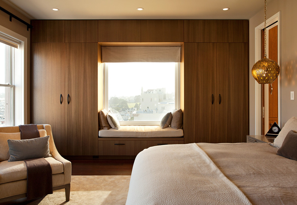 Diseño de dormitorio moderno con paredes beige y suelo de madera oscura