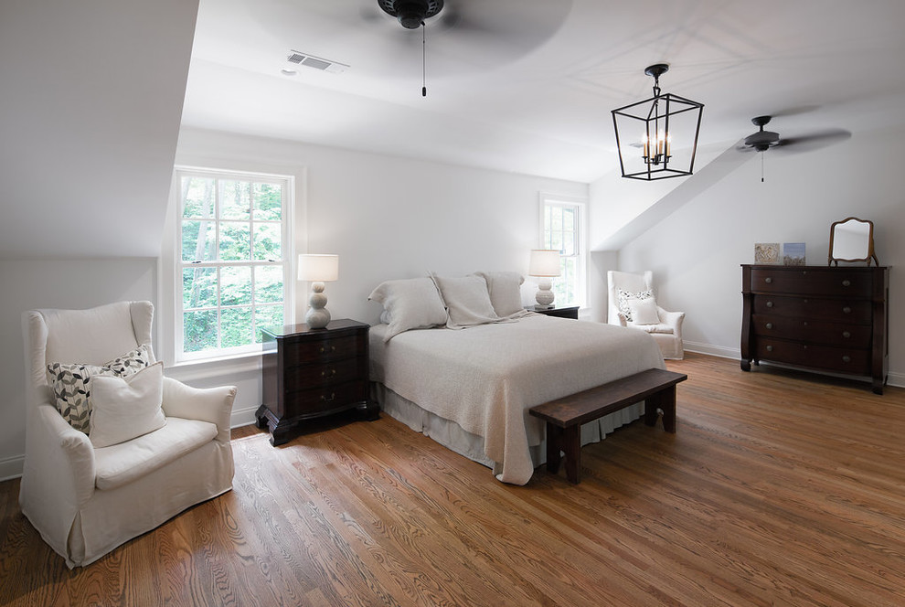 Imagen de dormitorio principal clásico grande sin chimenea con paredes grises, suelo de madera en tonos medios y suelo marrón