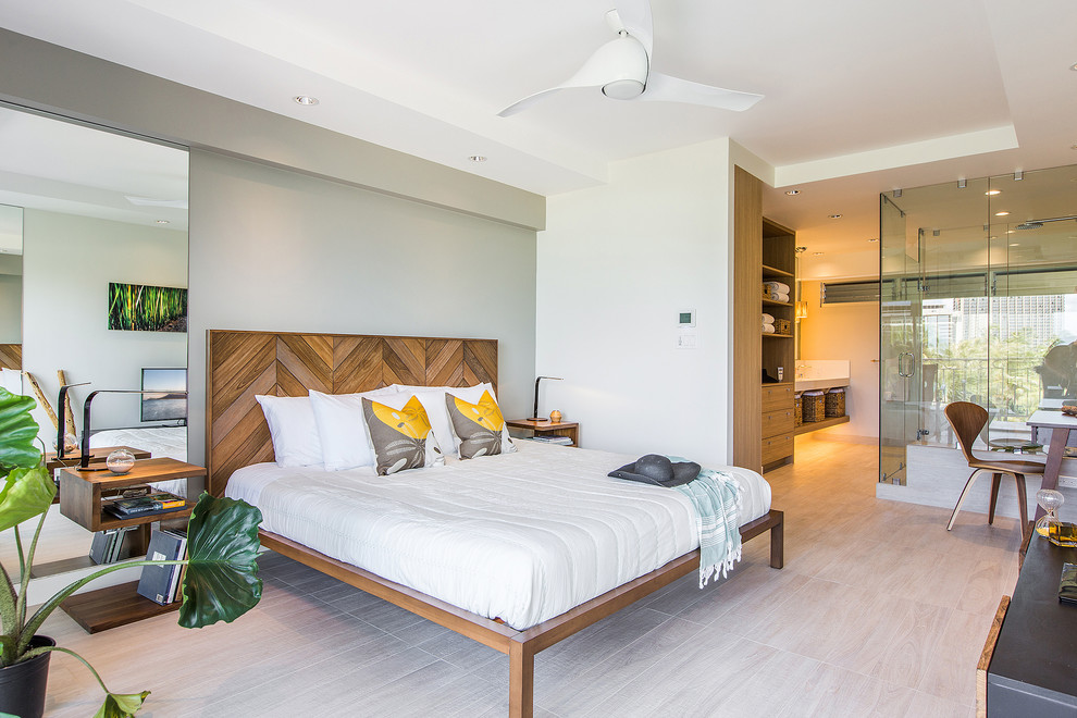 Diseño de dormitorio principal exótico grande sin chimenea con paredes blancas, suelo de madera clara y suelo beige