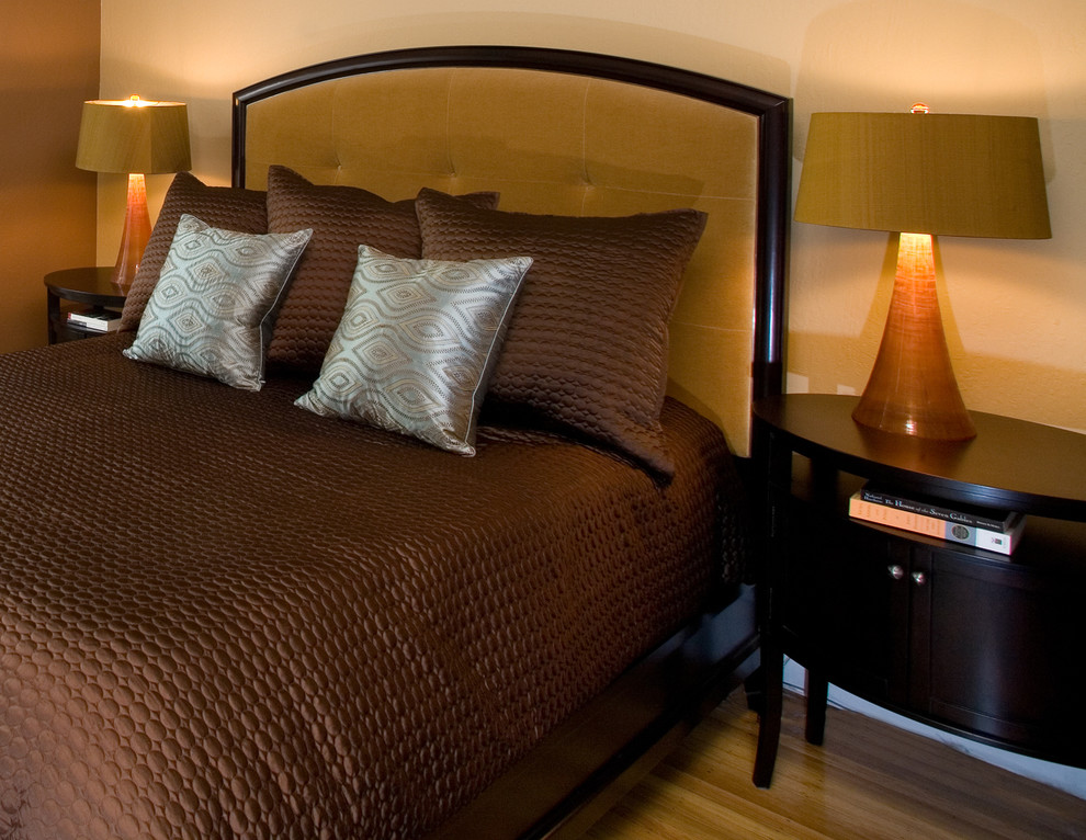 Diseño de dormitorio principal clásico de tamaño medio sin chimenea con paredes marrones, suelo de madera clara y suelo beige