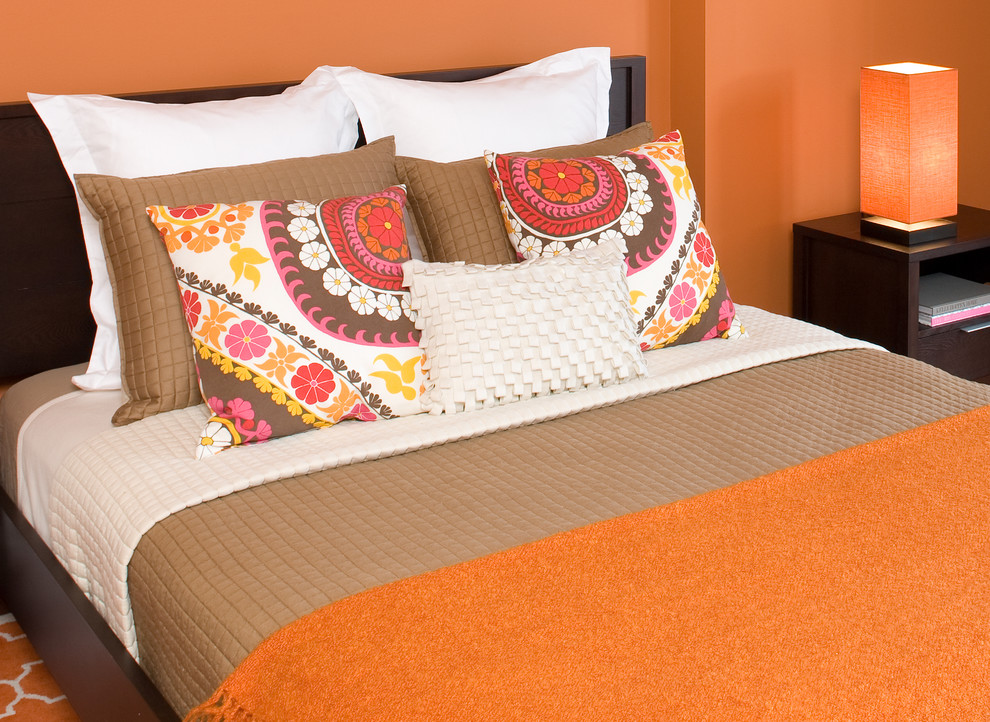 Imagen de habitación de invitados actual de tamaño medio sin chimenea con parades naranjas y suelo de madera en tonos medios