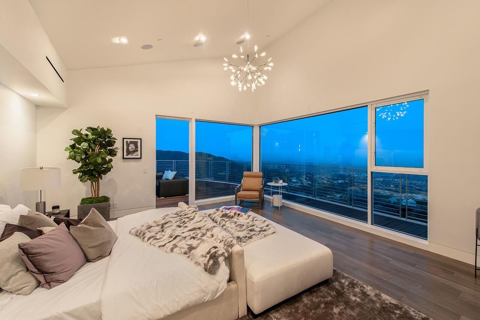 Ejemplo de habitación de invitados minimalista grande con paredes blancas, suelo de madera en tonos medios y suelo marrón