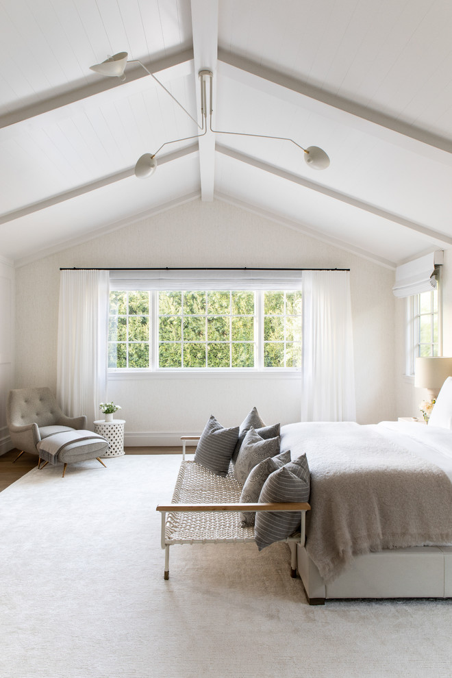 Foto di una grande camera degli ospiti minimalista con pareti beige, parquet chiaro e pavimento beige