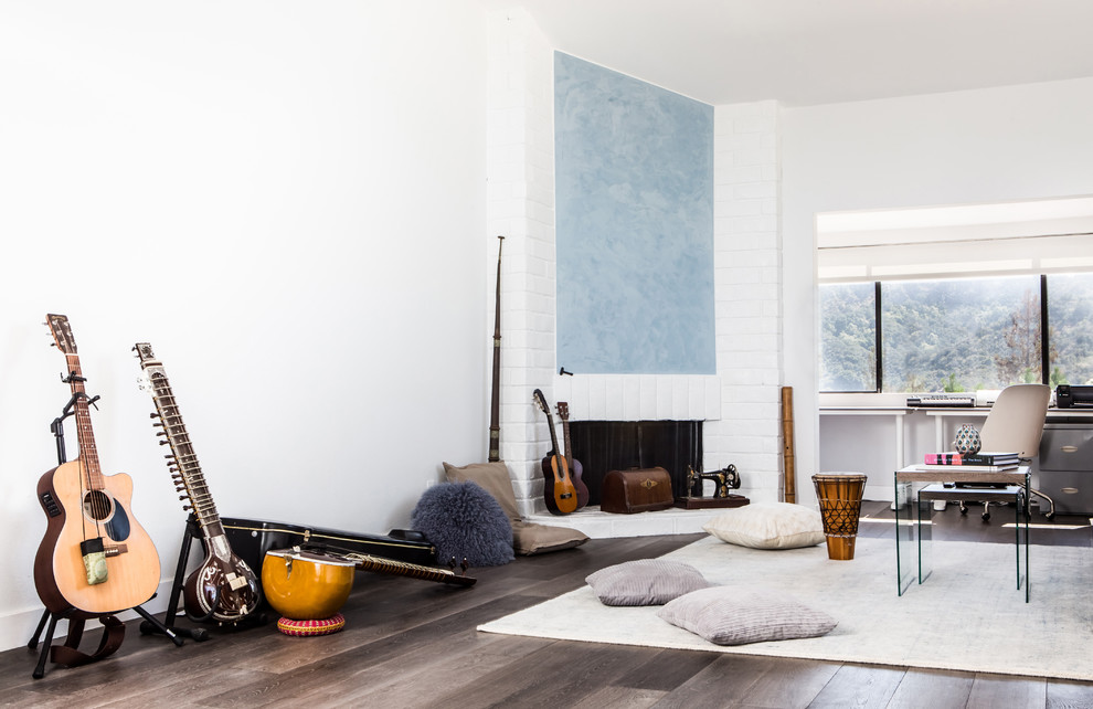Großes Modernes Schlafzimmer im Loft-Style mit weißer Wandfarbe, dunklem Holzboden, Kamin und Kaminumrandung aus Backstein in Los Angeles