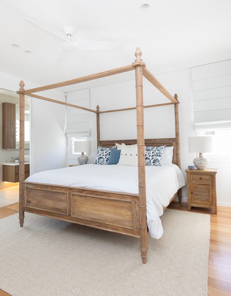 Maritimes Schlafzimmer mit weißer Wandfarbe, braunem Holzboden und braunem Boden in Sonstige