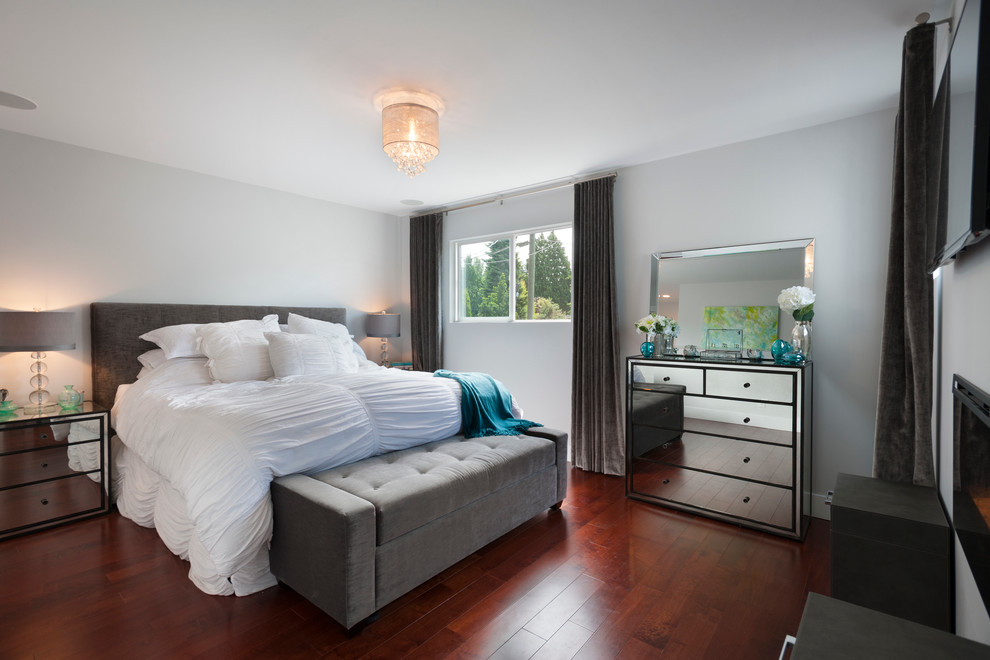 Свежая идея для дизайна: хозяйская спальня среднего размера в стиле неоклассика (современная классика) с серыми стенами, паркетным полом среднего тона и стандартным камином - отличное фото интерьера