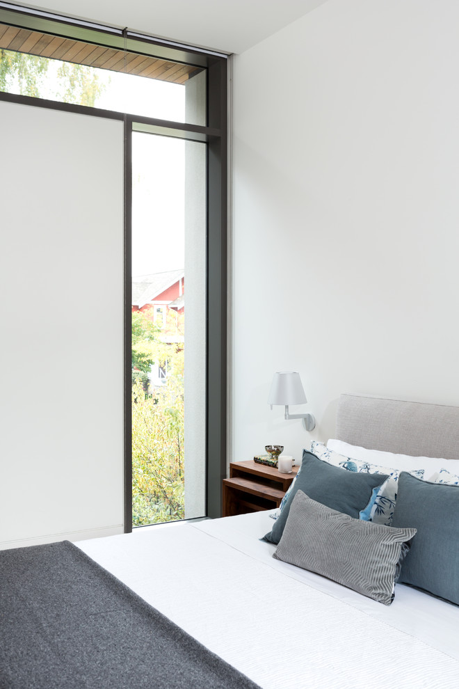 Стильный дизайн: маленькая хозяйская спальня в современном стиле с белыми стенами и коричневым полом для на участке и в саду - последний тренд