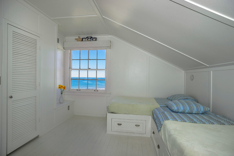 サンタバーバラにある中くらいなビーチスタイルのおしゃれな客用寝室 (白い壁、塗装フローリング、暖炉なし)
