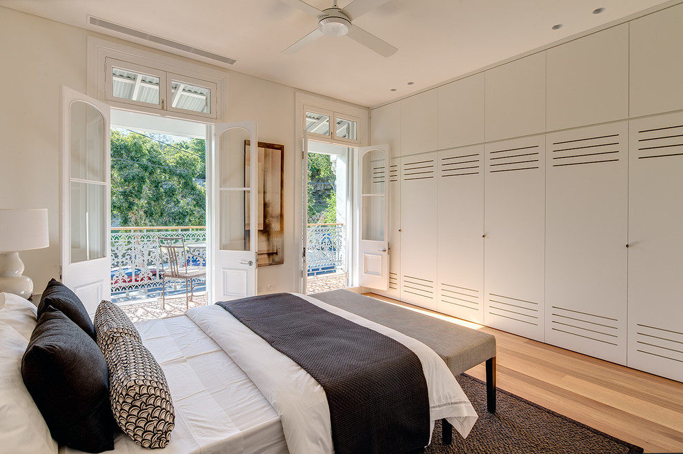 На фото: хозяйская спальня среднего размера в стиле модернизм с белыми стенами и светлым паркетным полом без камина