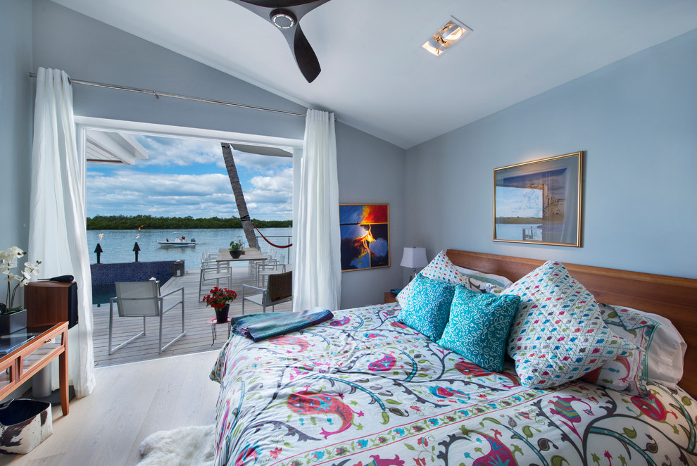 Diseño de habitación de invitados contemporánea grande sin chimenea con paredes azules y suelo de madera clara