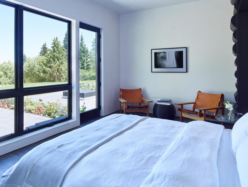 This is an example of a contemporary guest bedroom in Jackson with white walls and dark hardwood flooring.