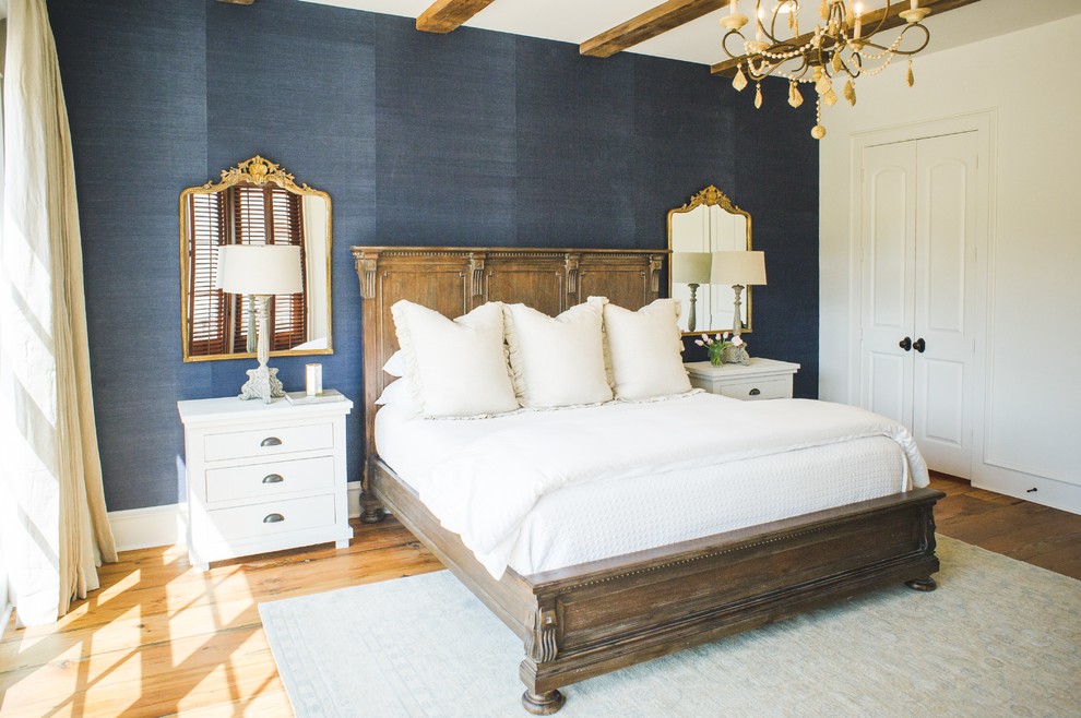 Idée de décoration pour une grande chambre parentale tradition avec un mur bleu, un sol en bois brun, aucune cheminée et un sol marron.