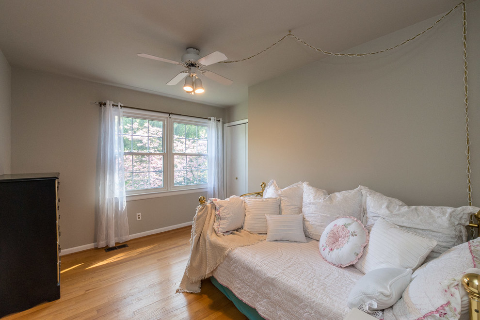 Cette photo montre une petite chambre d'amis chic avec un mur gris, parquet clair, aucune cheminée et un sol beige.